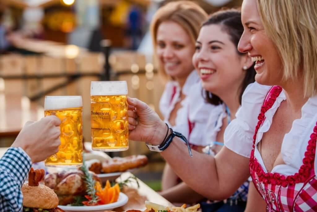 Smiling patrons enjoying Oktoberfest beer