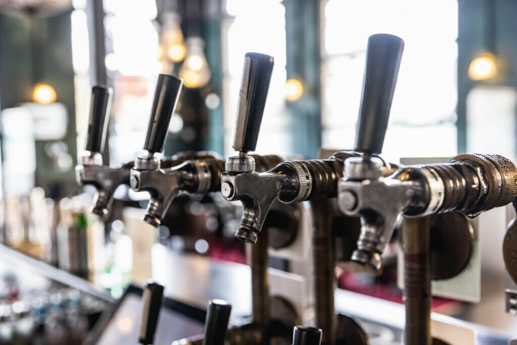 Close-up of stainless steel beer taps at a bar, professionally installed for commercial beverage service.