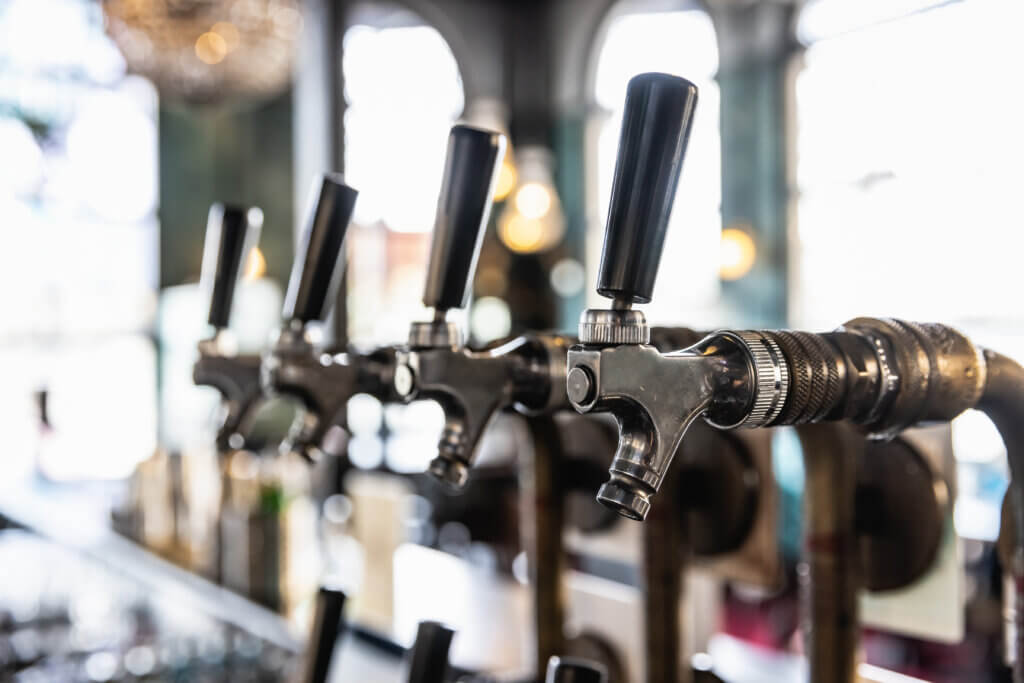 Close-up of stainless steel beer taps at a bar, professionally installed for commercial beverage service.